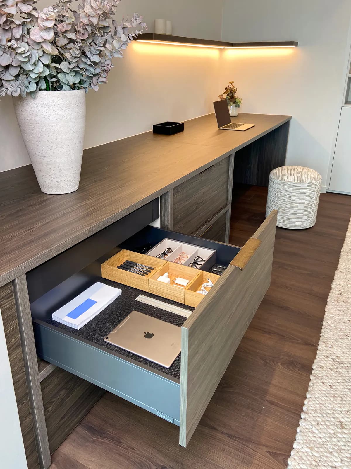 Bureaulade met een houten indeling voor pennen, brillen en een tablet