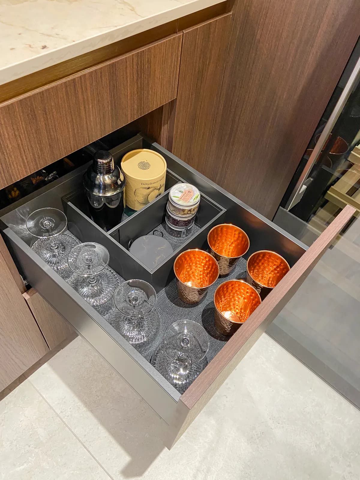 Lade met cocktailglazen, koperen bekers en een shaker